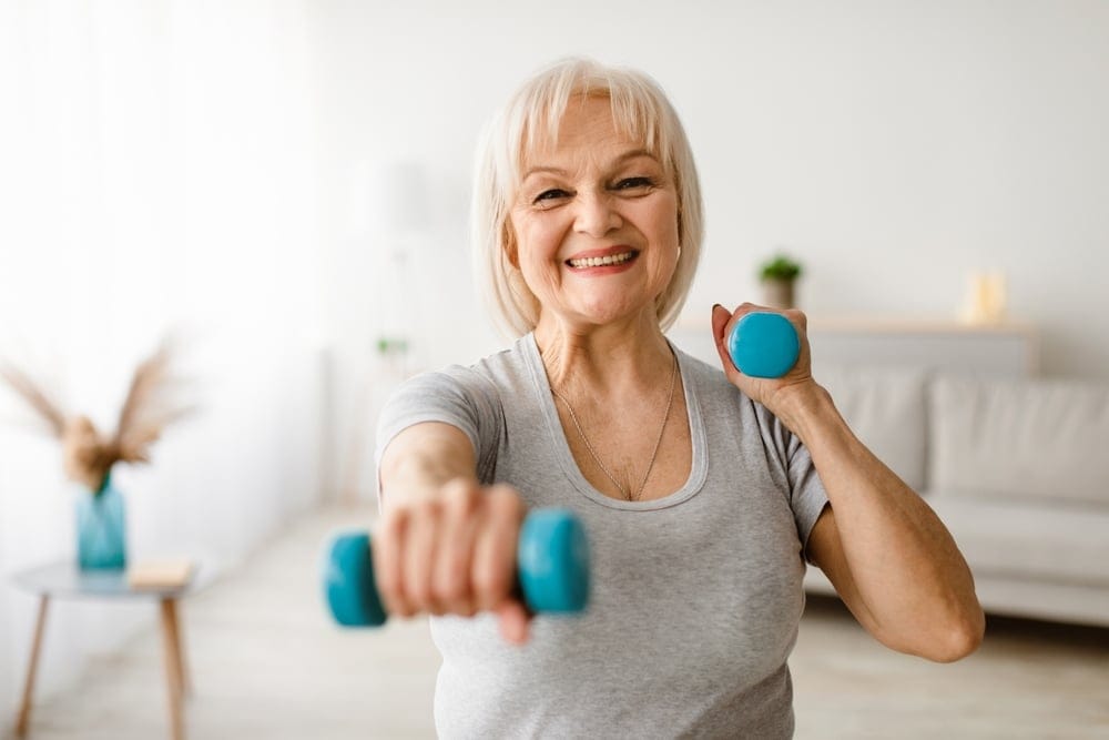 mature,woman,exercising,at,home,with,two,dumbbells