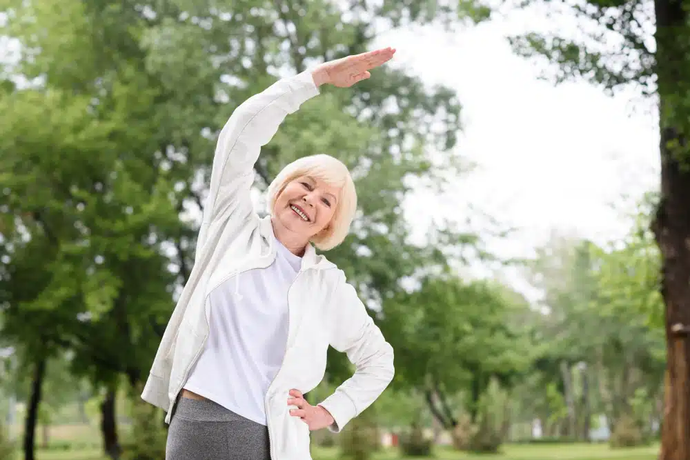 elderly,woman,in,sportswear,exercising,and,stretching,in,park