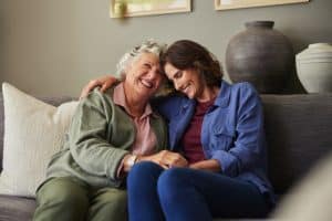 beautiful,old,mother,and,her,daughter,smiling,warmly,while,embracing