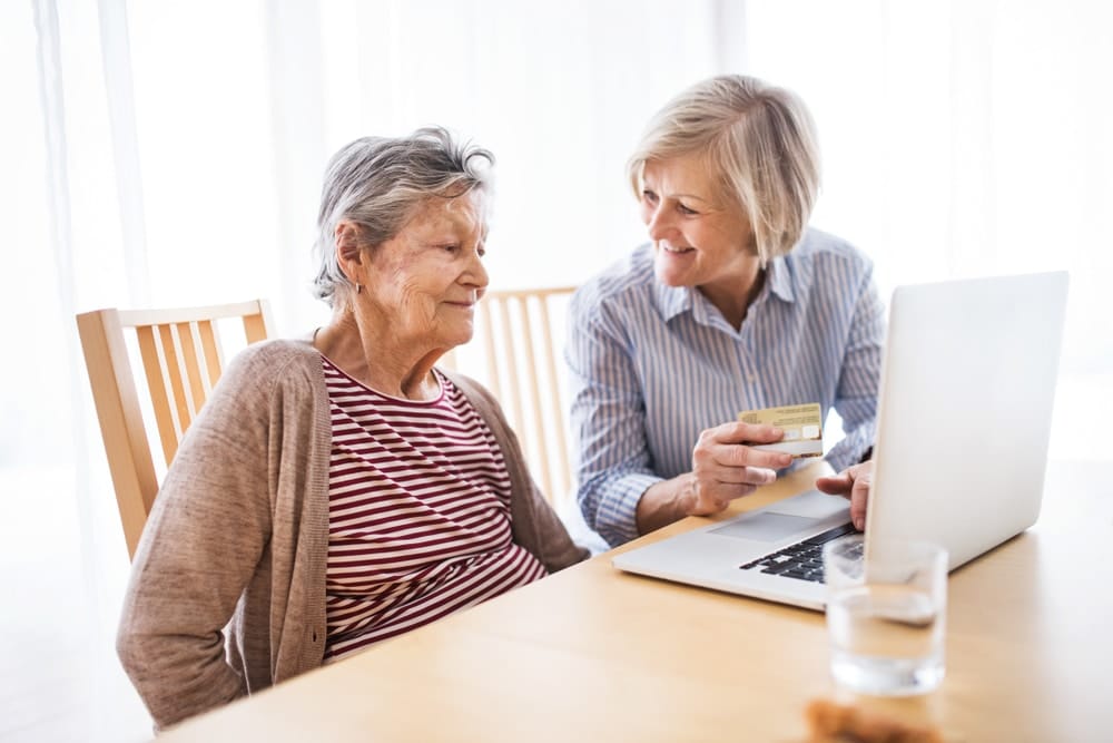 senior,woman,with,her,mother,with,laptop,at,home.