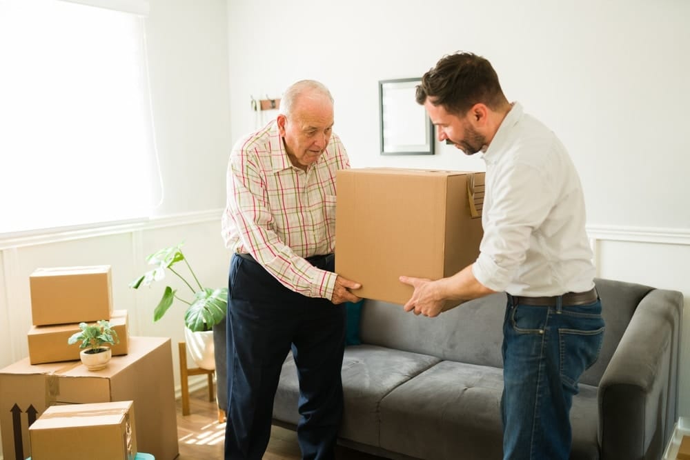 young,man,carrying,boxes,and,helping,his,elderly,caucasian,father