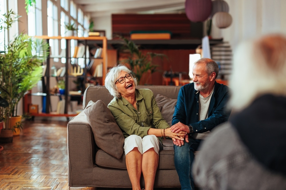 senior,couple,holding,hand,and,laughing,during,marriage,therapy,session