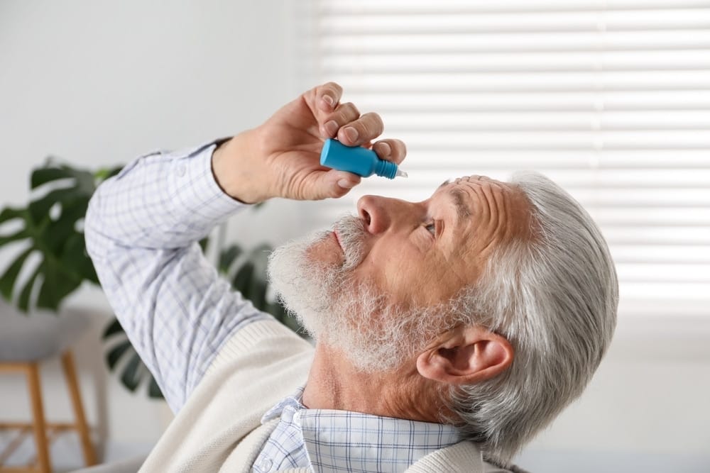 senior,man,applying,eye,drops,at,home