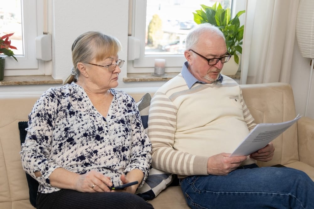 senior,couple,reviewing,important,documents,at,home,,showing,concern,and