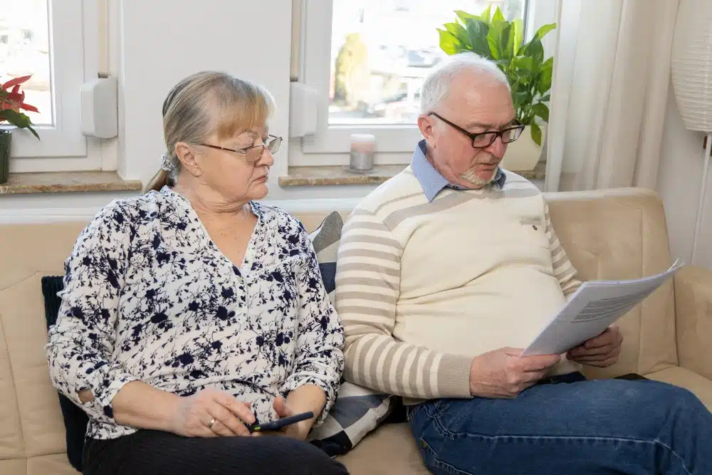 senior,couple,reviewing,important,documents,at,home,,showing,concern,and