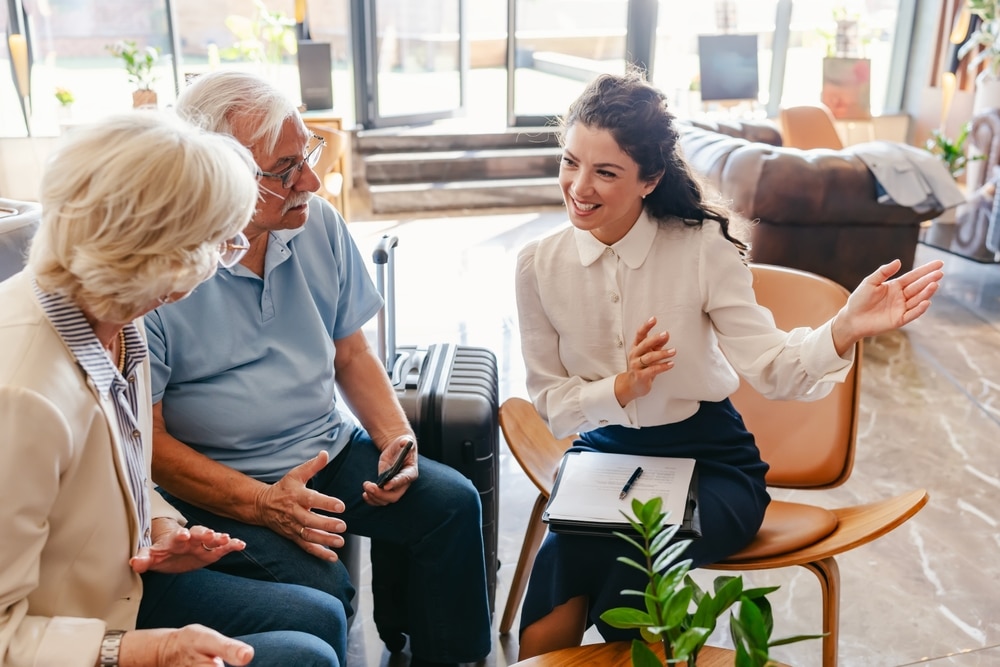 an,elderly,couple,sits,in,a,modern,hotel,lobby,,talking