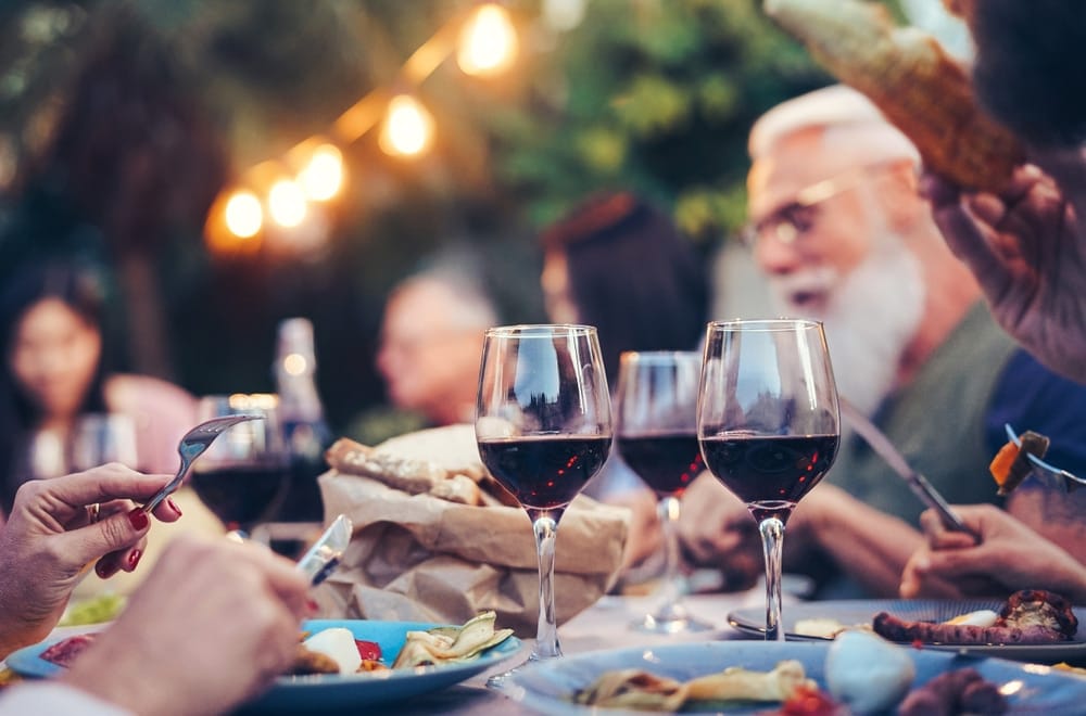 happy,family,eating,and,drinking,red,wine,at,dinner,barbecue