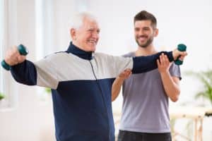 senior,man,after,stroke,at,nursing,home,exercising,with,professional