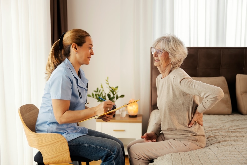side,view,of,nurse,at,her,home,visit,sitting,in