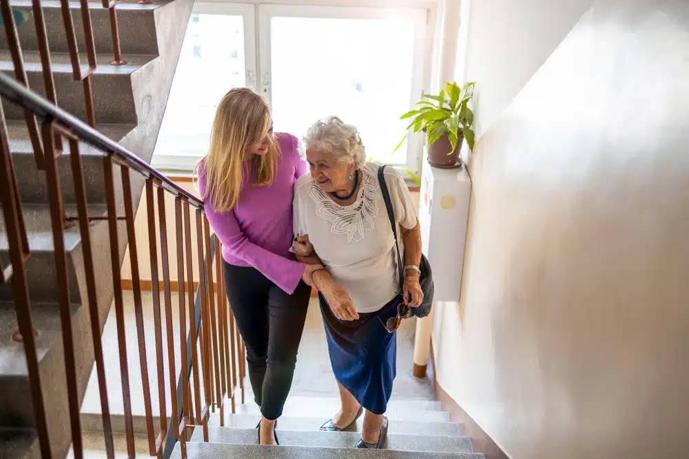 caregiver,helping,senior,woman,climb,staircase