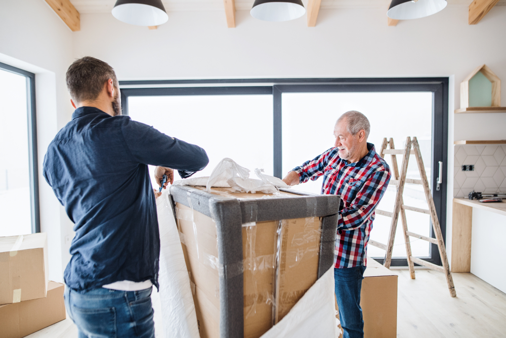 a,senior,man,helping,his,son,with,furnishing,new,house,