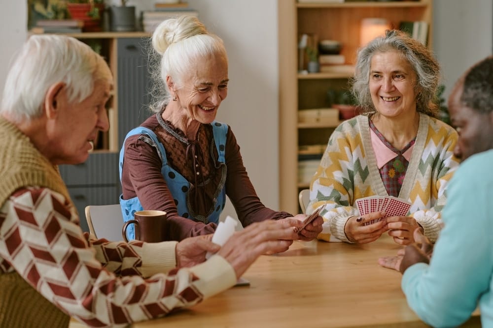 senior,people,smiling,and,enjoying,playing,cards,together,in,nursing