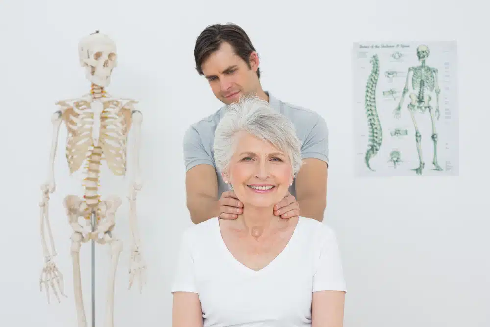 male,physiotherapist,massaging,a,senior,woman's,neck,in,the,medical