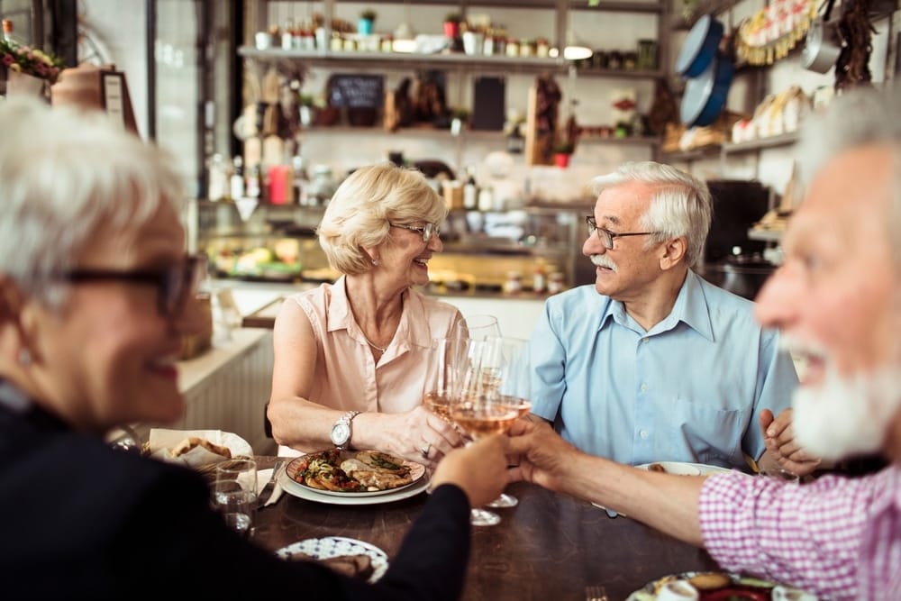 happy,senior,friends,eating,at,a,cozy,bistro,together