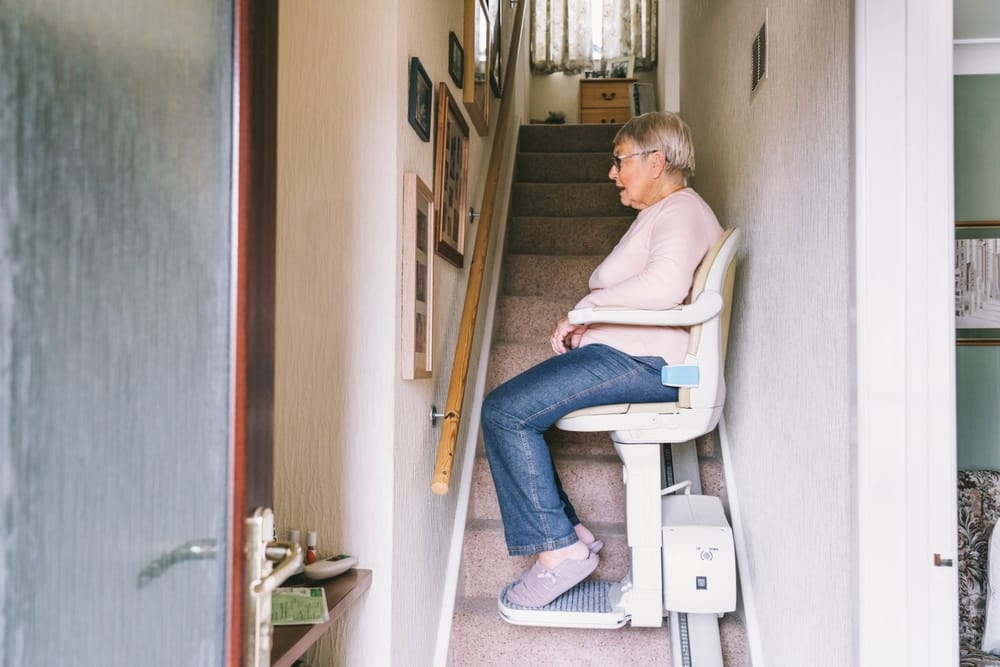 senior,woman,using,automatic,stair,lift,on,a,staircase,at