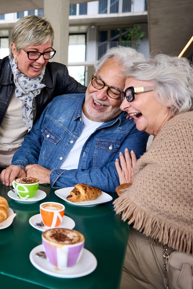 vertical.,three,mature,grey,hair,friends,laughing,together,enjoying,snacks