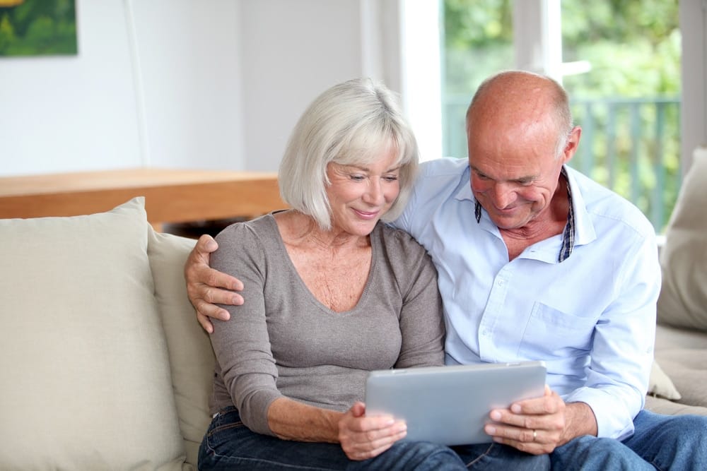senior,couple,using,electronic,tablet,at,home