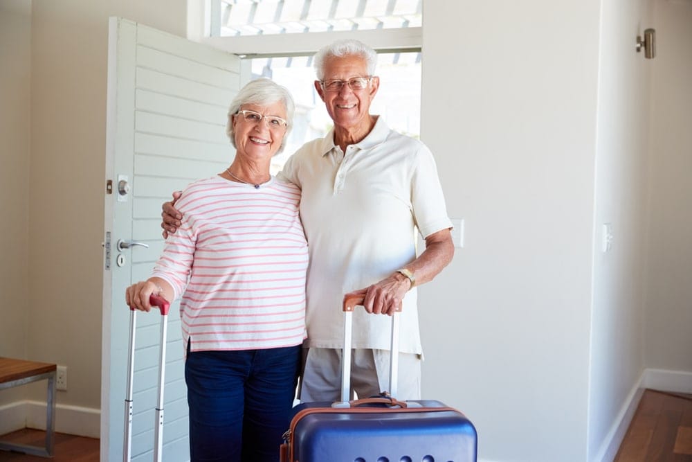 portrait,of,senior,couple,arriving,at,summer,vacation,rental