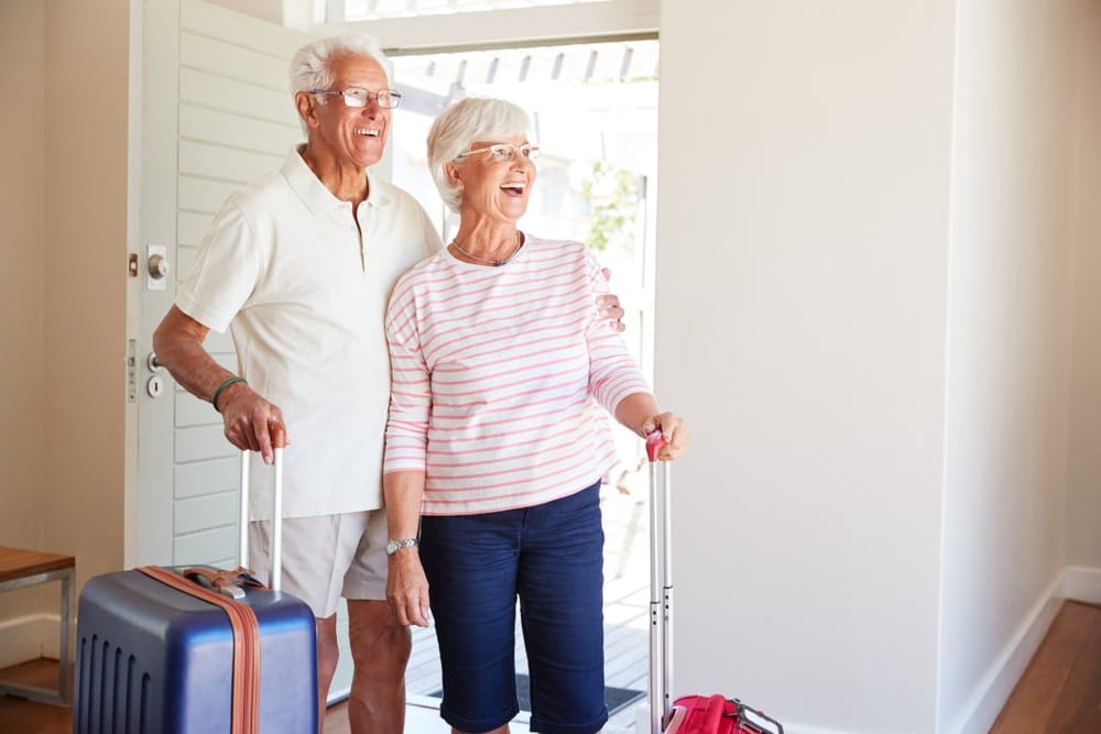 senior,couple,arriving,at,summer,vacation,rental