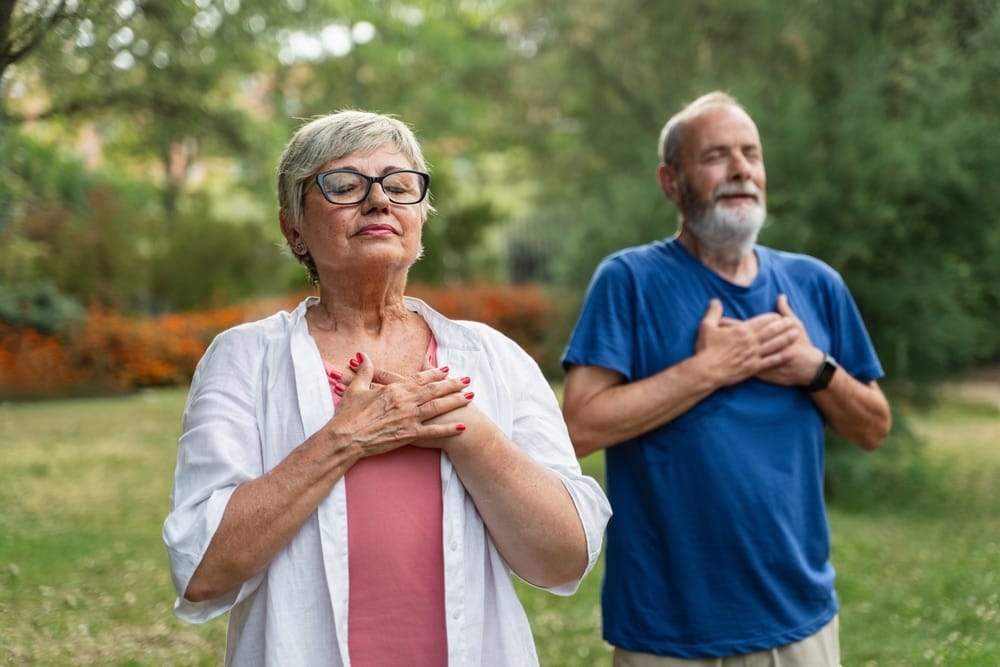 healthy,senior,couple,holding,hands,on,chest,,breathing,fresh,air,