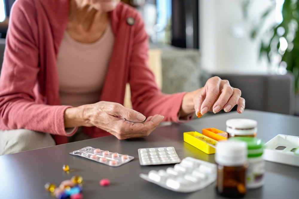 senior,woman,organizing,medications,at,home,,carefully,placing,pills,into